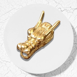 Detailed macro shot of a golden dragon head charm with intricate metal carvings