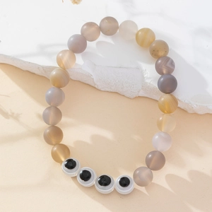 Detail of beaded evil eye bracelet with natural agate stones and matte finish texture