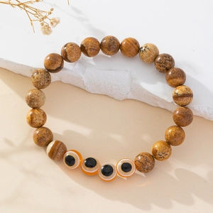 Detailed macro view of handmade evil eye beaded bracelet with brown natural stones