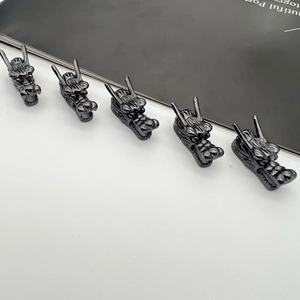 Macro detail of five gun-black alloy dragon head charms for DIY vintage jewelry making