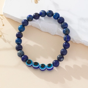 Macro view of blue lapis lazuli beads and glass evil eye charms on a beaded bracelet