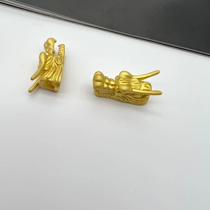 Macro view of two matte gold dragon head beads for DIY jewelry making accessories