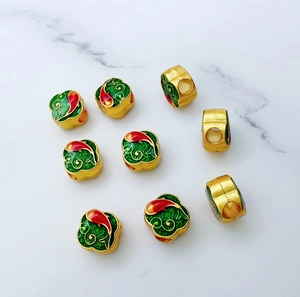 Macro detail of nine gold-plated enamel koi fish beads with red and green floral patterns