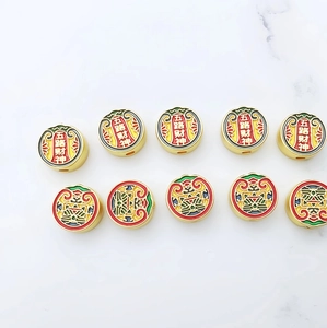 Macro view of gold alloy beads featuring colorful enamel Five Wealth Gods Chinese motifs