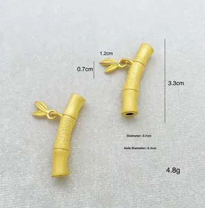 Detailed view of bamboo style jewelry connector with matte gold finish and leaf charm