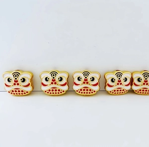 Detail of red and white enamel lion dance charms with gold-tone zinc alloy outlines