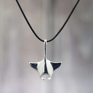 Polished silver manta ray pendant on a minimalist black cord with reflective finish