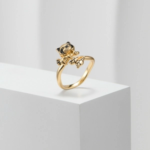 Detailansicht eines goldenen Waschbär-Rings mit schwarzer Emaille und Blattakzent