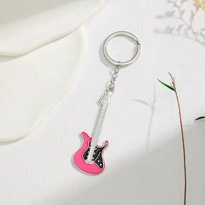 Close-up of pink guitar keychain with enamel finish and silver metal chain detail