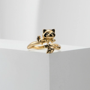 Detailaufnahme des goldenen Waschbär-Rings mit schwarzen Emaillierungen und Blattstruktur
