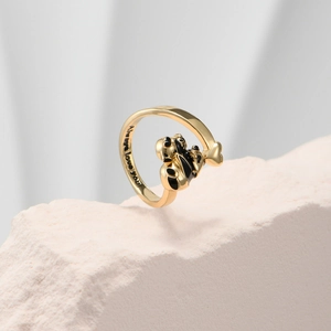Detaillierte Makroansicht der Gravur Always love you in dem Panda-Ring aus Emaille und Gold