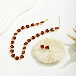 Detailopname van rode kristallen kralenketting en bijpassende oorknopjes op decoratie