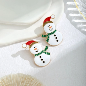 Macro shot of snowman earrings with red enamel Christmas hat and green striped scarf