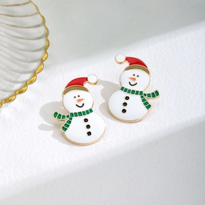 Detailed close-up of snowman earrings with red hats and green scarves on stone
