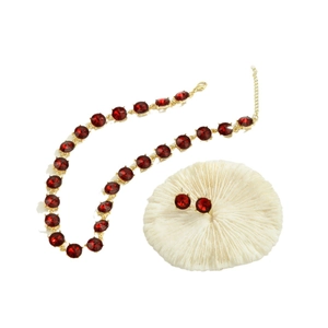 Elegante gouden sieradenset met rode gefacetteerde edelstenen en een rode kralenketting