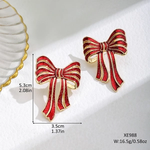 Detail view of red bow earrings with size measurements of 5.3cm height and 3.5cm width