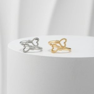 Detail of gold and silver open rings featuring double heart-shaped rope textures