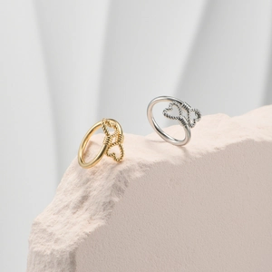 Detail of gold and silver woven heart rings on stone base with soft shadows