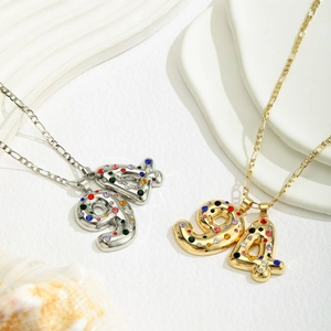 Close-up of number 9 and 4 pendant necklaces with colorful rhinestones in gold and silver