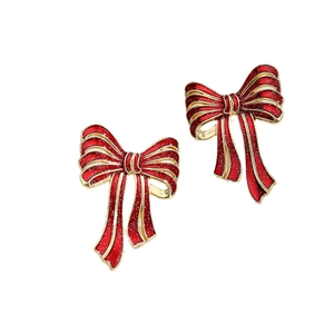 Festive red glitter bow earrings with gold plating and enamel finish on white background