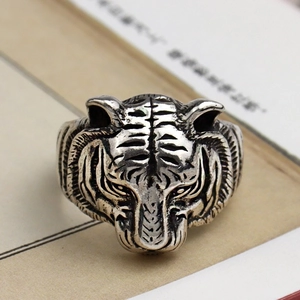 Macro shot of silver vintage tiger head ring with antique finish on book pages