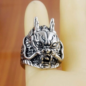 Macro detail of the 3D dragon head sculpture on an antique silver punk ring