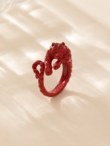 Macro shot of a red glazed metal tiger ring with soft natural window shadows