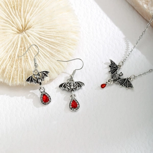 Detail of red water drop gems and bat shaped alloy jewelry set with small diamonds