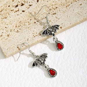 Detailed view of Gothic bat earrings with red pear-shaped resin stones and silver alloy
