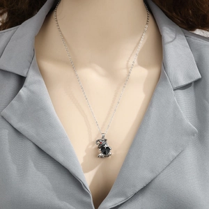 Detail of gothic ghost pendant with black heart gemstone on a silver necklace
