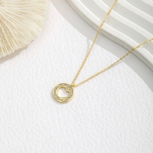 Detailopname van een gouden hart hanger met dubbele rijen fonkelende kristallen aan ketting