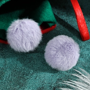 Detailed view of two light purple plush faux fur round earrings with soft texture
