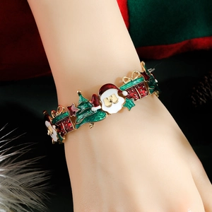 Detail eines Weihnachts-Armbands mit Weihnachtsmann- und Baum-Anhängern am Handgelenk