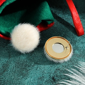 Detailed macro view of white faux fur pompom earrings with golden metal base