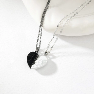 Detail view of heart-shaped magnetic necklaces with black and white enamel and portrait art