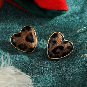 Vista macro di orecchini a forma di cuore con stampa leopardata e base dorata