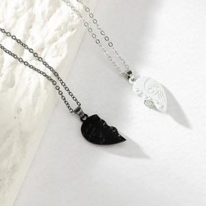 Macro shot of magnetic abstract face pendant necklaces in black and white finish