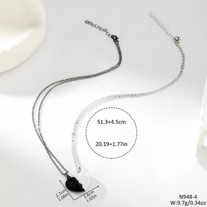 Close-up of heart-shaped magnetic couple necklaces with minimalist face profile engraving