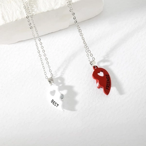 Detailed macro of magnetic heart necklaces with Best Friends engraving and red white enamel