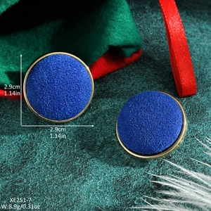 Detailed view of circular blue flocked earrings with gold metal frame and size markings