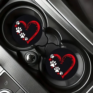 Close-up of two car coasters with red heart and paw prints inside vehicle cup holder