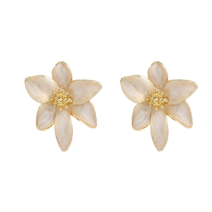 Elegantes pendientes de flores con pétalos crema marmoleados y estambres dorados en blanco