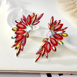Macro shot of wing-shaped earrings with red marquise rhinestones and iridescent gems
