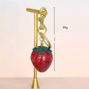 Sparkly red strawberry keychain with green leaves and golden metal lobster clasp