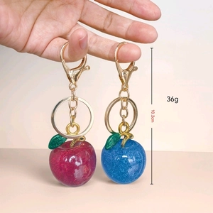 Sparkling glitter resin apple keychain in magenta and blue with golden alloy ring