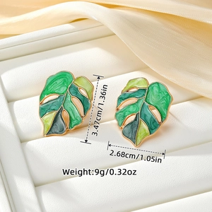 Golden alloy monstera leaf earrings with green enamel coating for a stylish summer look