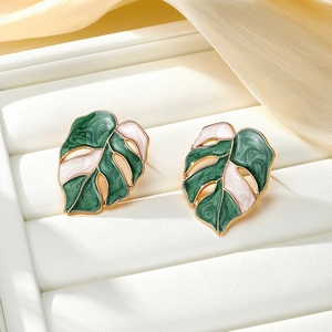 Detail of Monstera leaf earrings with green marble enamel on golden metal base