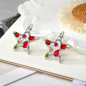 Detailed macro view of starfish earrings with colorful crystal inlay on textured silver base