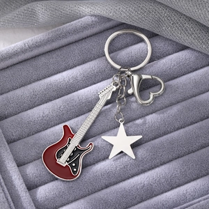 Detailed macro view of Y2K style guitar keychain with a silver star and heart-shaped clasp