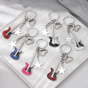 Detailed close-up of six colorful Y2K guitar keychains with star charms in a ceramic bowl